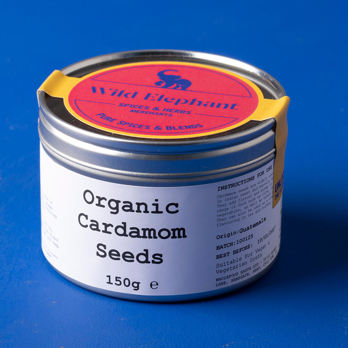 Close-up of organic cardamom seeds in a glass jar, showcasing their green-brown pods, from Whole Food Earth’s herbs and spices collection.