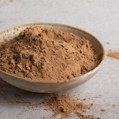 Organic Whole Food Earth carob powder in a container, showcasing the natural, fine brown powder for baking and health uses.