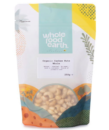 Whole Food Earth organic whole cashew nuts in a clear bowl, showcasing their creamy, curved shape and light beige color.