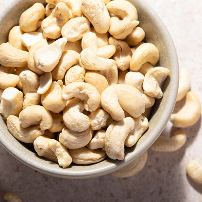 Whole Food Earth organic whole cashew nuts, raw and unroasted, displaying their creamy beige color and curved shape.