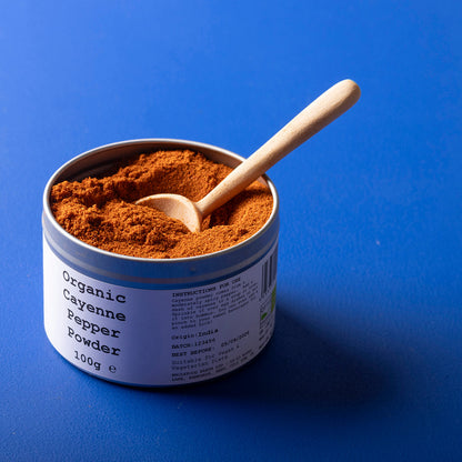 Organic cayenne pepper powder from Wild Elephant, a vibrant red spice in a clear jar, perfect for adding heat to dishes.