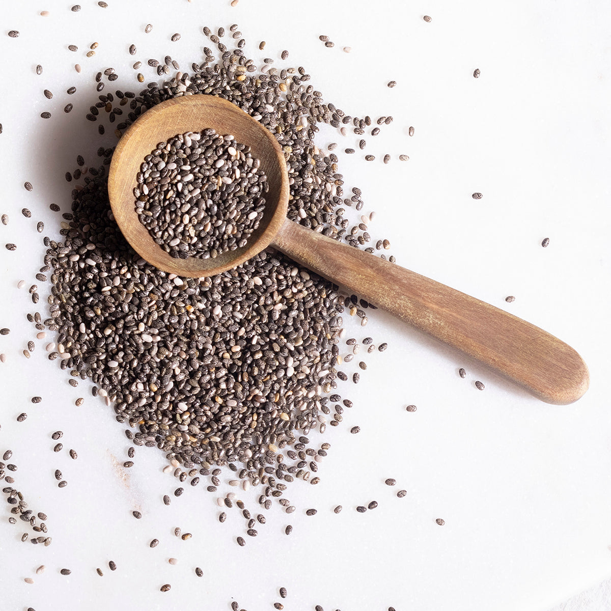 Organic chia seeds from Whole Food Earth in a clear bowl, showcasing small black and white seeds on a white background.