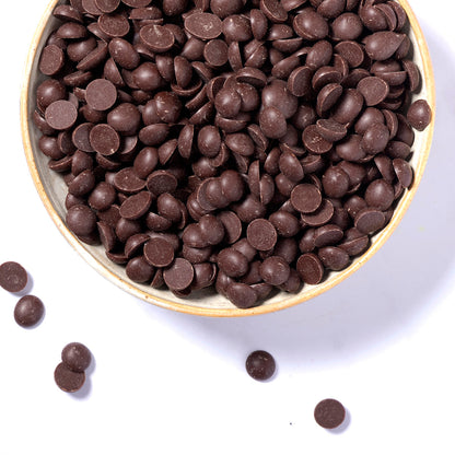 Close-up of organic chocolate drops from Whole Food Earth, showing glossy, dark chocolate pieces on a neutral background.