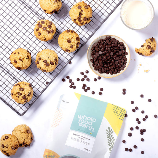 Organic chocolate drops from Whole Food Earth shown in a bowl with a rustic setting, highlighting natural, sweet candy treats.