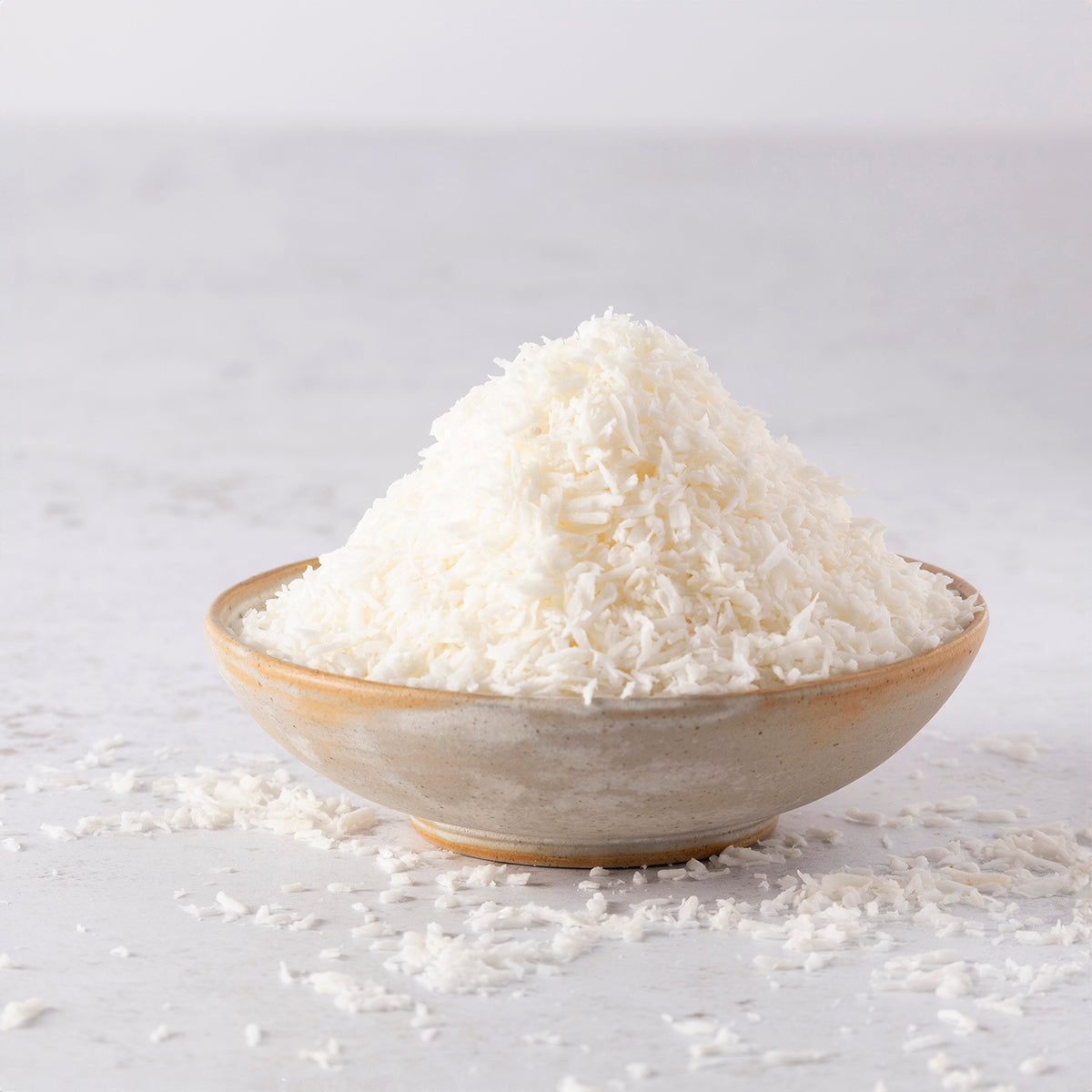 Organic coconut desiccated in a bowl, dried shredded coconut from Whole Food Earth, suitable for baking and snacking.