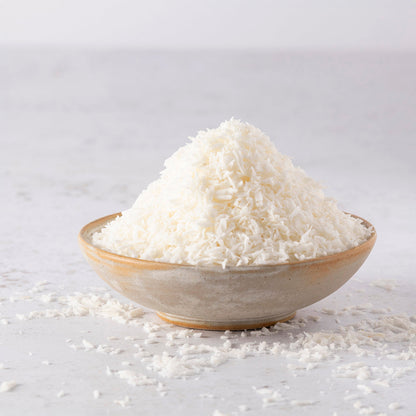 Organic coconut desiccated in a bowl, dried shredded coconut from Whole Food Earth, suitable for baking and snacking.