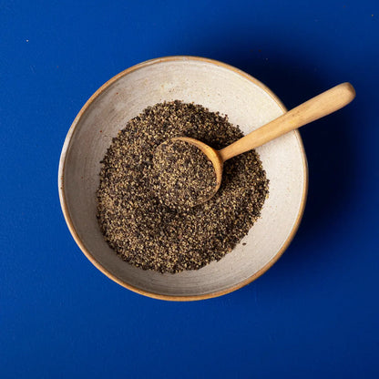 Organic cracked black pepper from Wild Elephant, whole herbs and spices, shown in a clear jar with fresh cracked pepper visible.