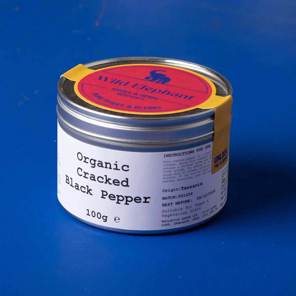 Organic cracked black pepper from Wild Elephant, Whole Food Earth herbs and spices, showing fresh, coarse black pepper in a glass jar.