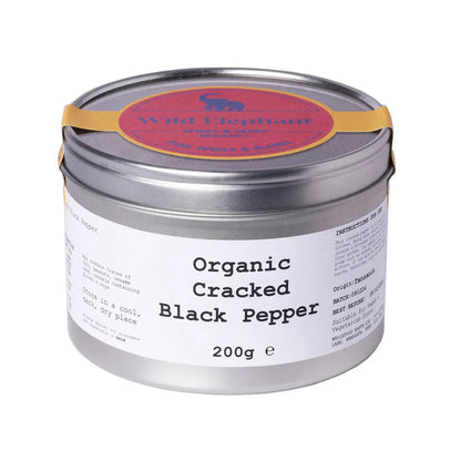 Organic cracked black pepper from Wild Elephant, whole herbs and spices in a glass jar, showcasing coarse black peppercorns.