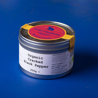 Organic cracked black pepper from Wild Elephant, a Whole Food Earth herb and spice, shown in a close-up image.