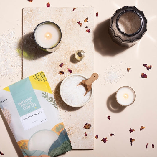 Organic Dead Sea salts from Whole Food Earth, displayed in a glass jar with a natural, spa-like setting and mineral crystals visible.