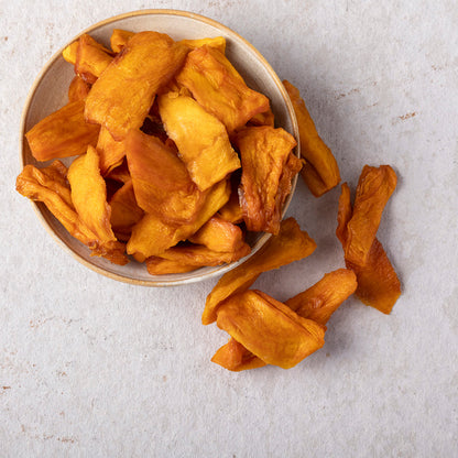 Organic dried mango slices from Whole Food Earth, showcasing vibrant, chewy dried fruit pieces on a white background.