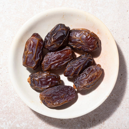 Organic dried Medjool dates from Whole Food Earth, showcasing plump, glossy, and rich-colored dried fruit on a neutral background.