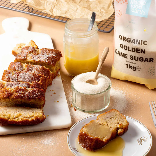 Organic Golden Cane Sugar from Whole Food Earth shown in a glass jar with a spoon and rustic background.