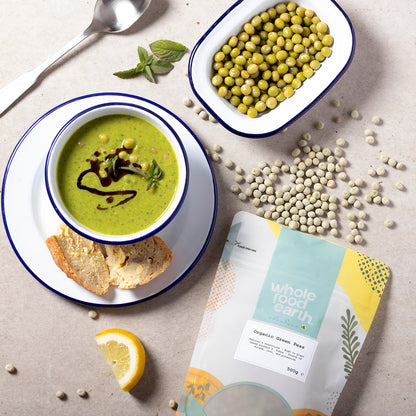 Fresh organic green peas in a bowl on a rustic wooden table, showcasing Whole Food Earth beans and pulses.