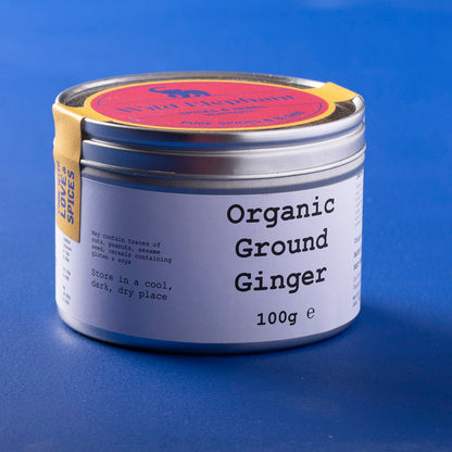Organic ground ginger from Whole Food Earth in a 100g package, shown in a jar of fresh, earthy ginger roots.