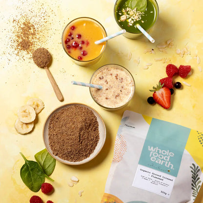 Organic ground flaxseed from Whole Food Earth, shown in a bowl with a spoon on a rustic wooden table.