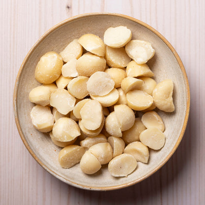 Organic Whole Food Earth macadamia nuts in a bowl, showcasing their creamy, crunchy texture and natural brown shells.
