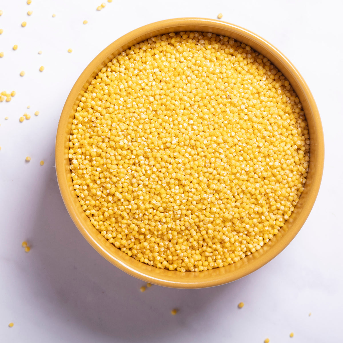 Organic millet grain from Whole Food Earth, showing small, round, light-colored millet grains in a clear bowl.