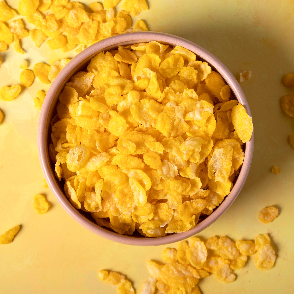 Organic natural corn flakes cereal by Whole Food Earth shown in a close-up image of the crispy, golden flakes on a white background.