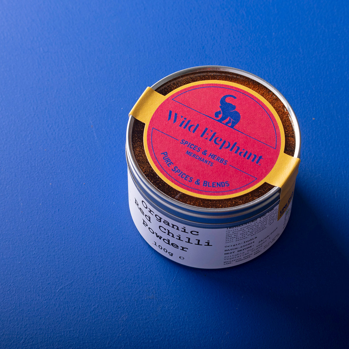 Organic red chilli powder by Whole Food Earth, 100g, in a clear container, showcasing vibrant red spice, part of herbs and spices collection.