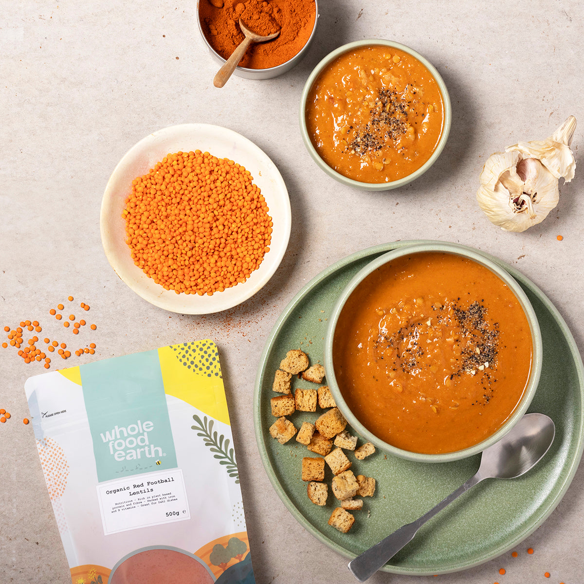 Organic red football lentils from Whole Food Earth, displayed in a kitchen setting with a bowl of cooked lentils.