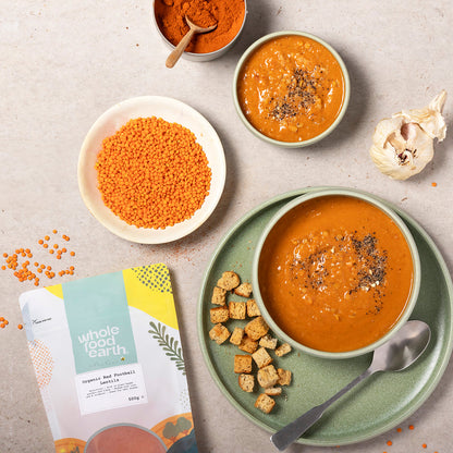 Organic red football lentils from Whole Food Earth, displayed in a kitchen setting with a bowl of cooked lentils.