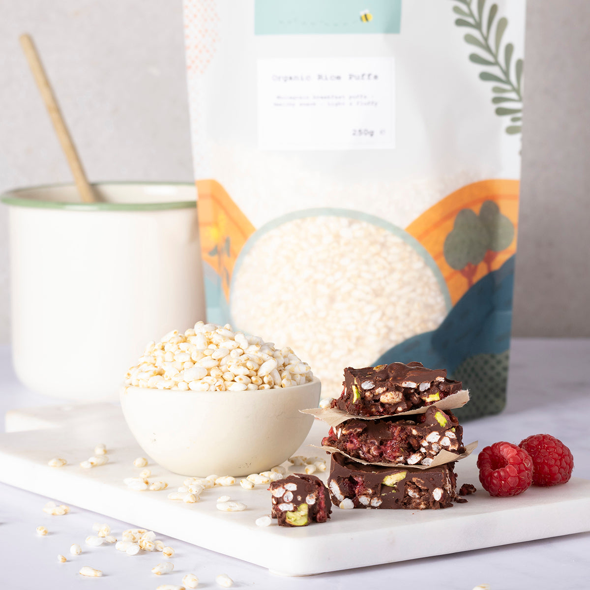 Organic Rice Puffs from Whole Food Earth, showing a bowl of crispy rice cereal on a wooden table with a spoon and fresh fruit.