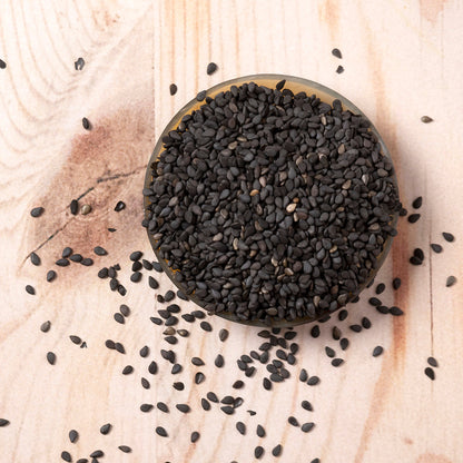 Black organic sesame seeds from Whole Food Earth, small round seeds with a black color, used as a nutritious nut and seed ingredient.