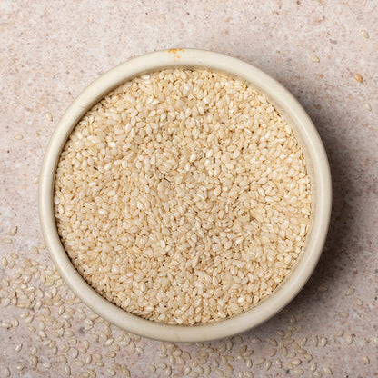 Organic hulled sesame seeds from Whole Food Earth, close-up of light tan, smooth seeds in a clear bowl, highlighting their nutty texture.
