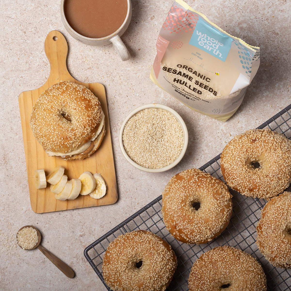 Organic hulled sesame seeds from Whole Food Earth displayed in a glass jar with a spoon on a rustic wooden background.