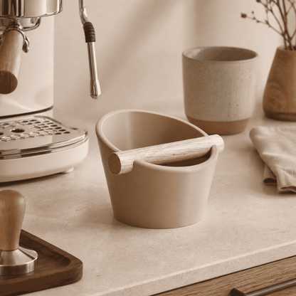 KNOCDIC® oval coffee knock box with a real oak wood bar for espresso shot disposal, shown on a kitchen countertop.
