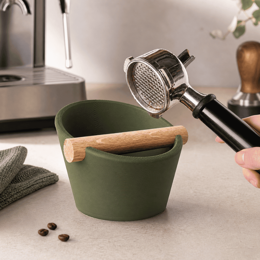 KNOCDIC® oval coffee knock box with real oak wood bar, used for espresso portafilter tamps, in a stylish kitchen setting