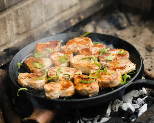 Primrose Herd pork tenderloin medallions, cut into steaks, fresh and uncooked, showcasing juicy, tender pork slices on a white surface.