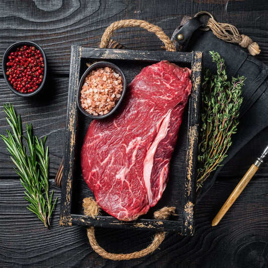 Prime Primrose Herd dry aged beef rump steak showing marbled beef cut on a wooden board.