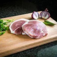 Smoked gammon steaks from Primrose Herd, thick slices of pork with a smoky glaze, ready for grilling or frying.