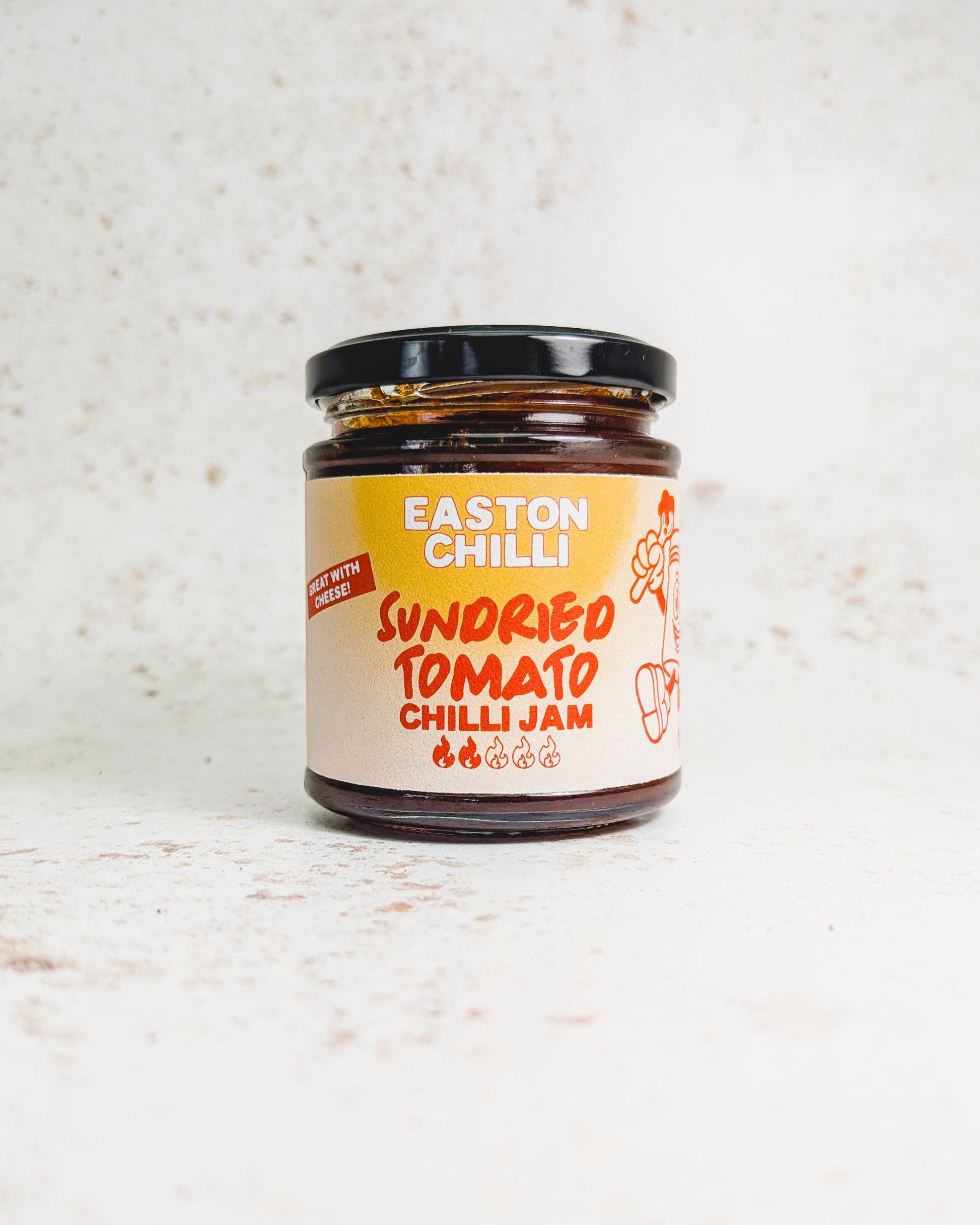 Sundried tomato chilli jam in a jar by Easton Chilli, with a spoonful showing its chunky, vibrant red and orange mixture.