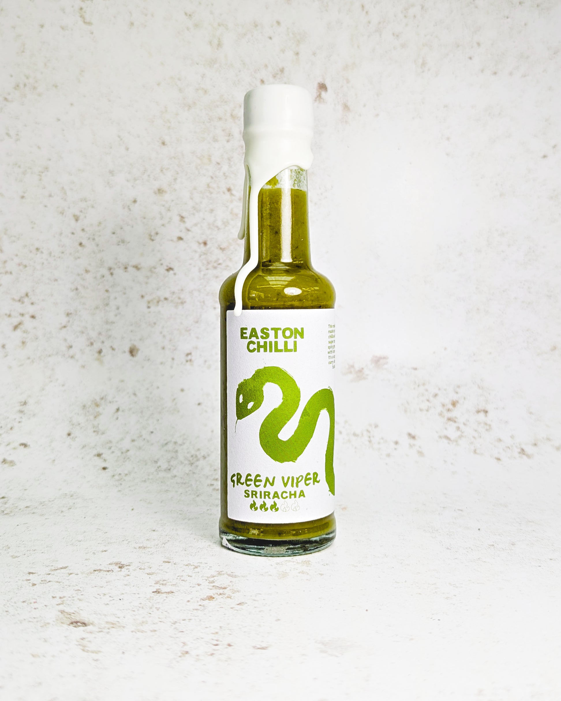 Green Viper Sriracha hot sauce by Easton Chilli, featuring a vibrant green chili pepper in a clear glass bottle.