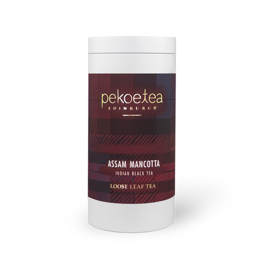 PekoeTea Edinburgh Assam Mancotta tea in a caddy, showcasing dark tea leaves and packaging with the brand logo.