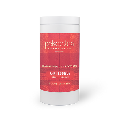 Box of PekoeTea Edinburgh Chai Rooibos tea in a decorative caddy with tea bags visible inside.
