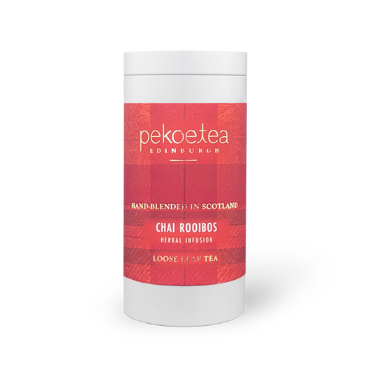Box of PekoeTea Edinburgh Chai Rooibos tea in a decorative caddy with tea bags visible inside.