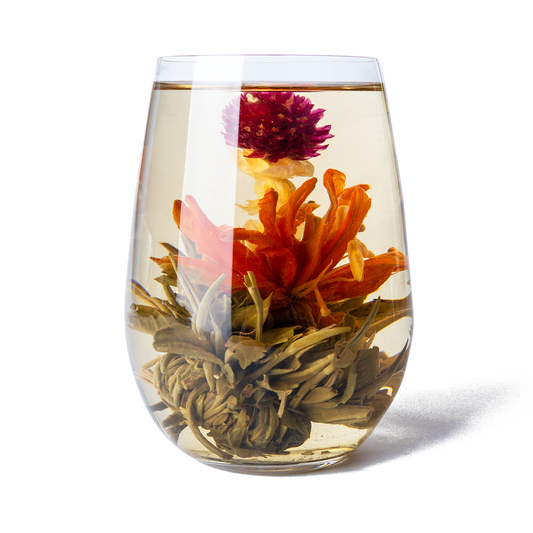 PekoeTea Edinburgh Divine Lily blooming tea in a glass, showcasing a delicate, flowering tea infusing with vibrant lily blossoms.