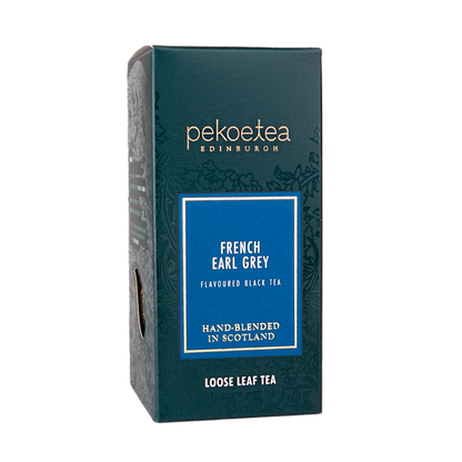 Loose leaf French Earl Grey tea by PekoeTea Edinburgh in a decorative box with tea leaves and a lemon slice.