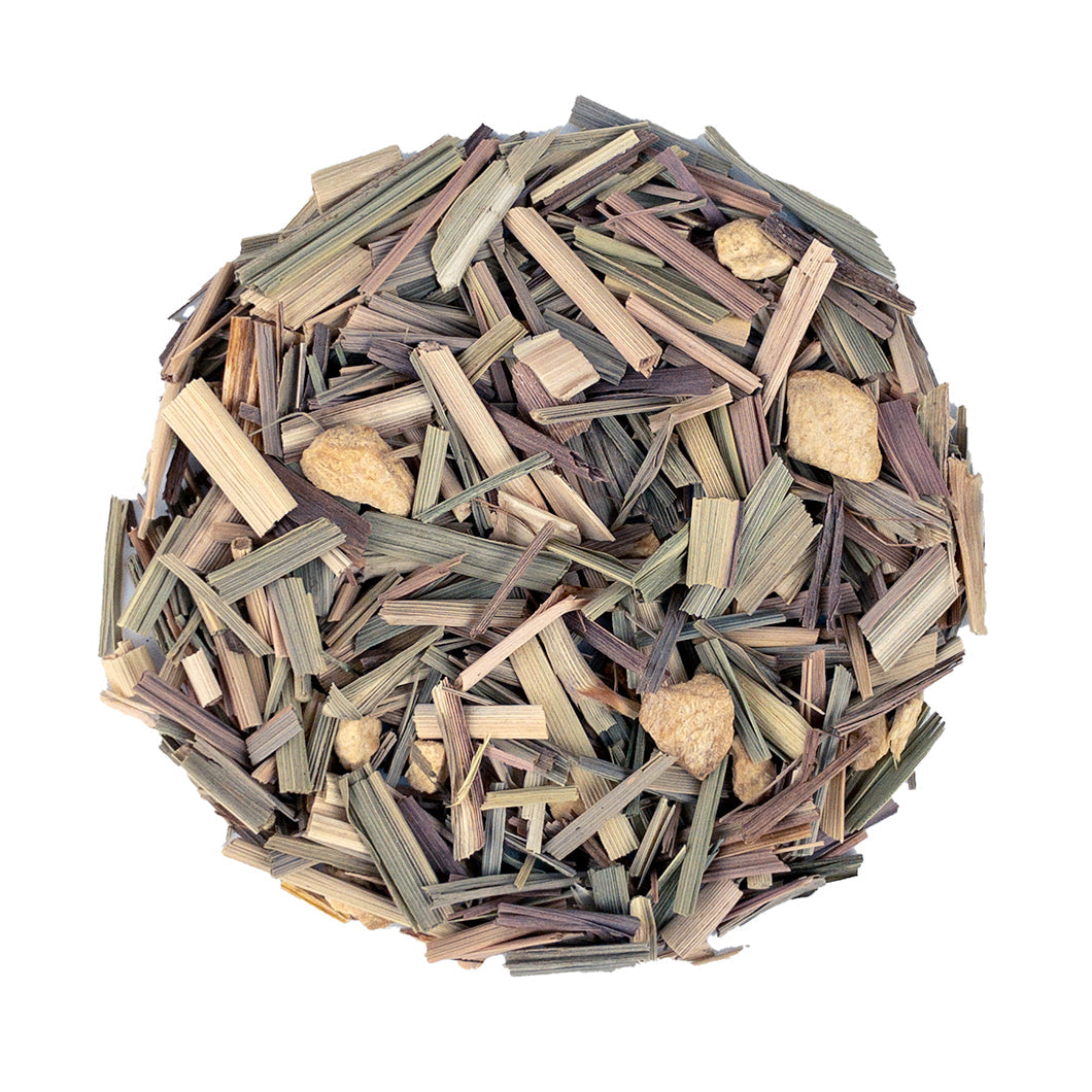 Fresh lemongrass and ginger tea leaves in a jar from PekoeTea Edinburgh, showcasing vibrant herbal ingredients.