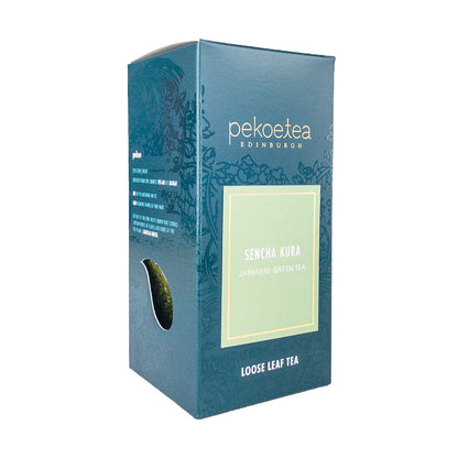 Box of PekoeTea Edinburgh Sencha Kura green tea, featuring vibrant packaging and fresh green tea leaves inside.