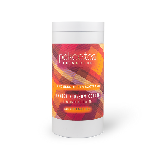 Orange Blossom Oolong Tea in a PekoeTea Edinburgh caddy, showcasing the elegant tea packaging with orange blossom floral accents.