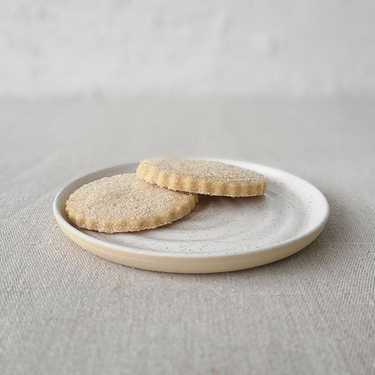 White ceramic Pepper White Classic Cake Plate by Katie L Thompson Designs, featuring a smooth round surface and elegant design.