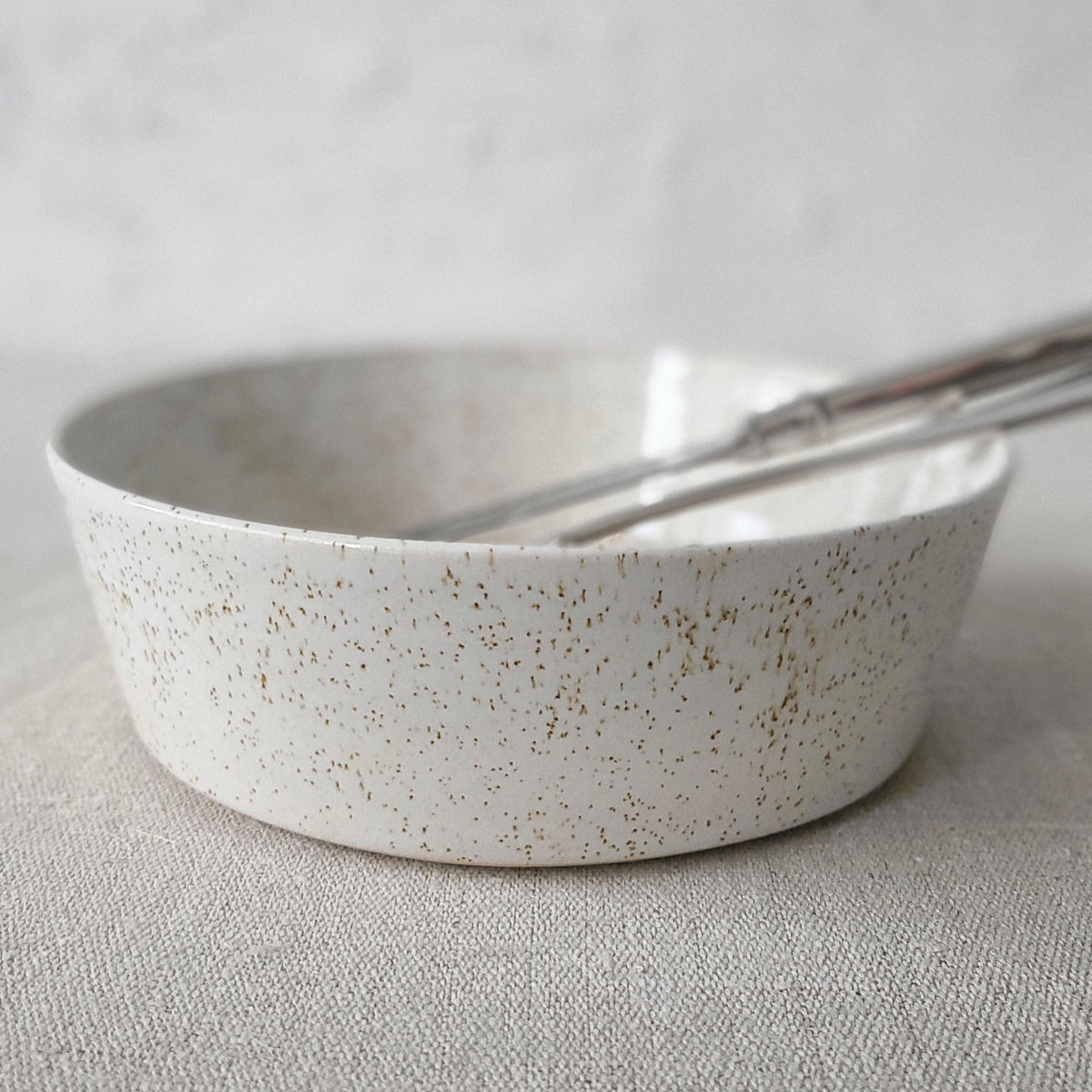 White ceramic Pepper White Classic Pasta Bowl by Katie L Thompson Designs with matching cutlery for serving pasta.