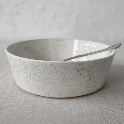 White ceramic Pepper White Classic Pasta Bowl by Katie L Thompson Designs with matching spoon on a neutral background.