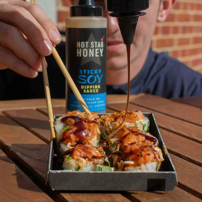 Asian-inspired Hot Star Honey sticky soy dipping sauce drizzled on sushi, showcasing its rich, glossy texture and deep flavor.